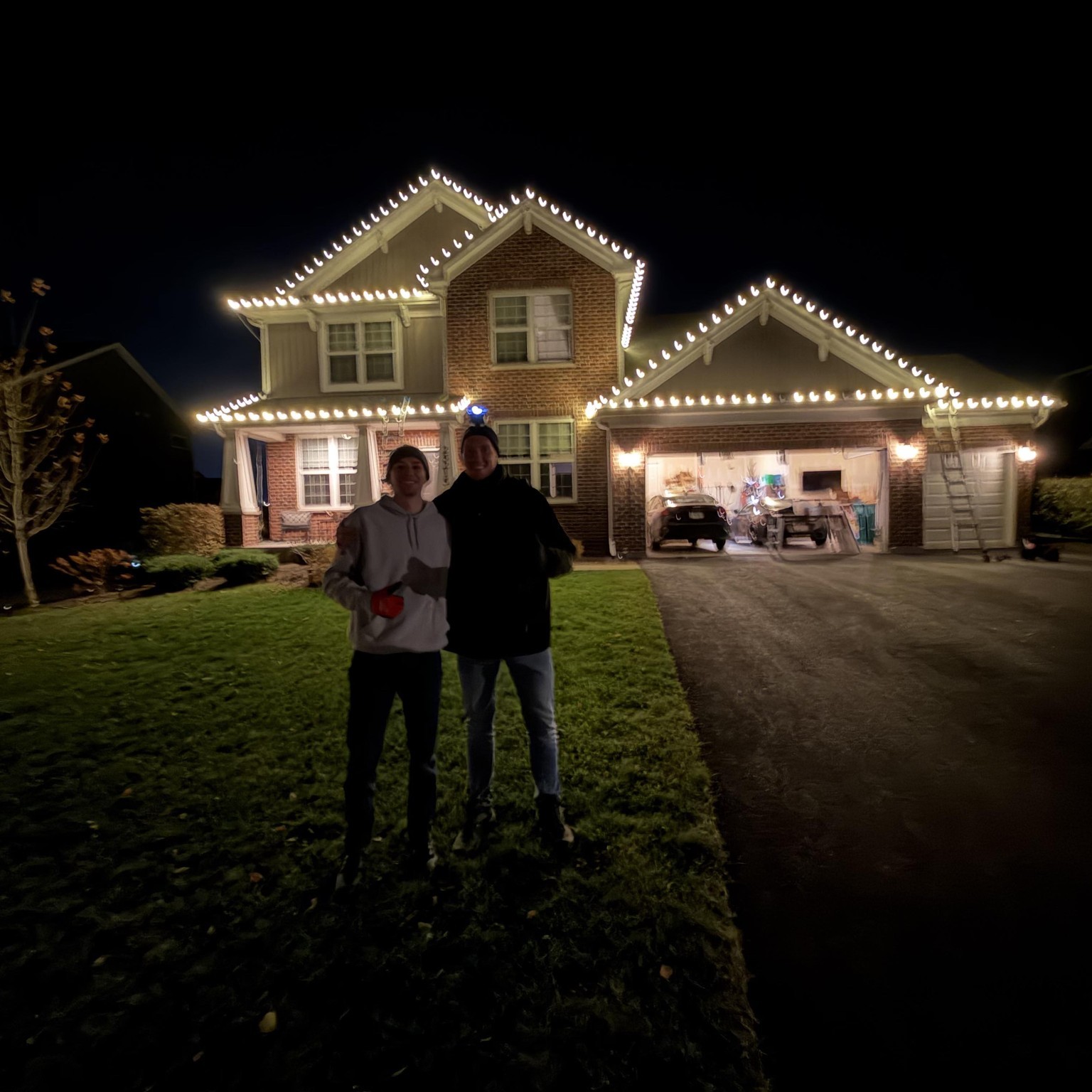 Christmas light installation on roofline and shrubs